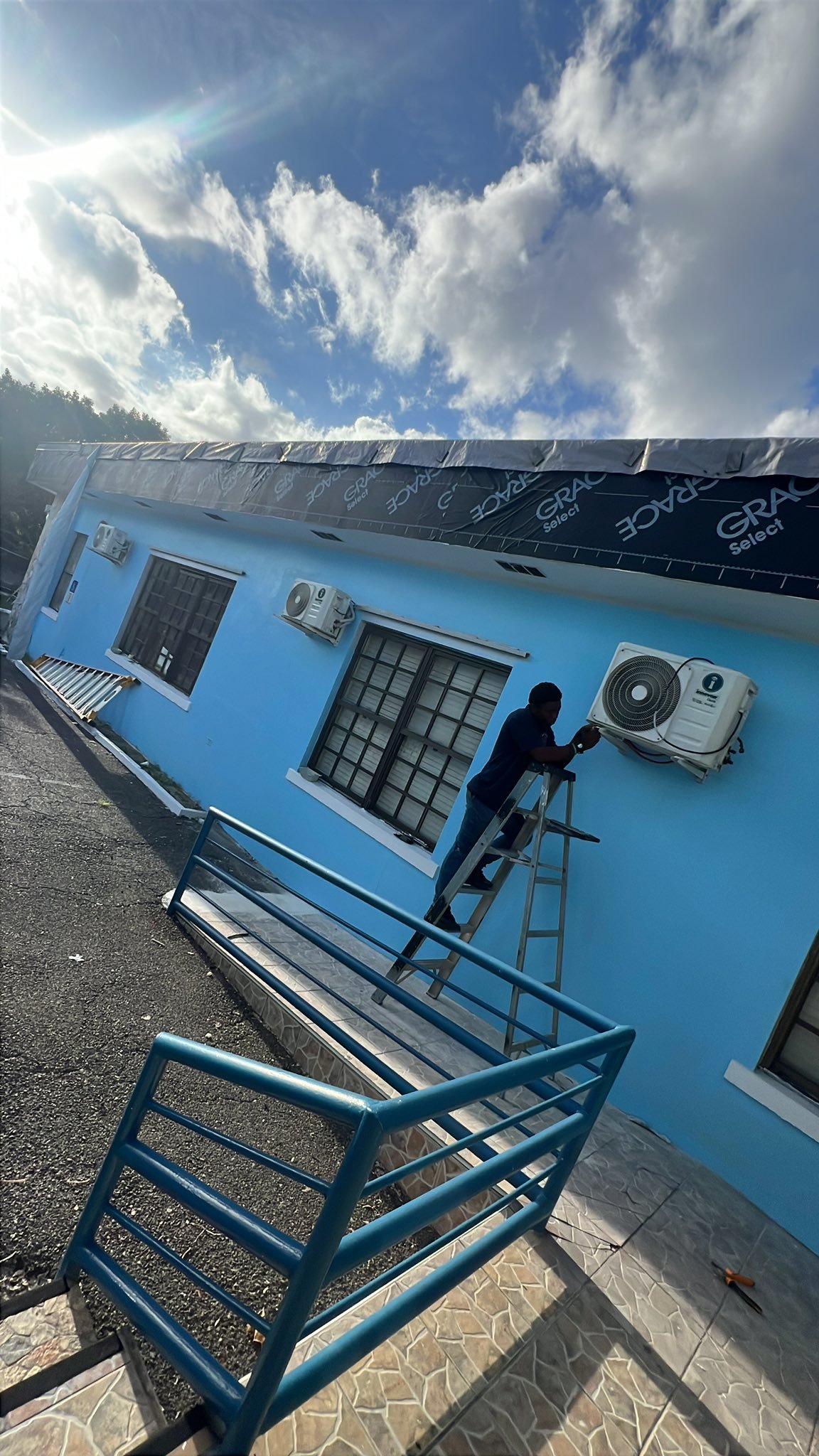 Multiple split AC units installed on exterior wall of a blue building