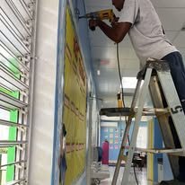 Technician mounting AC indoor unit on a commercial wall